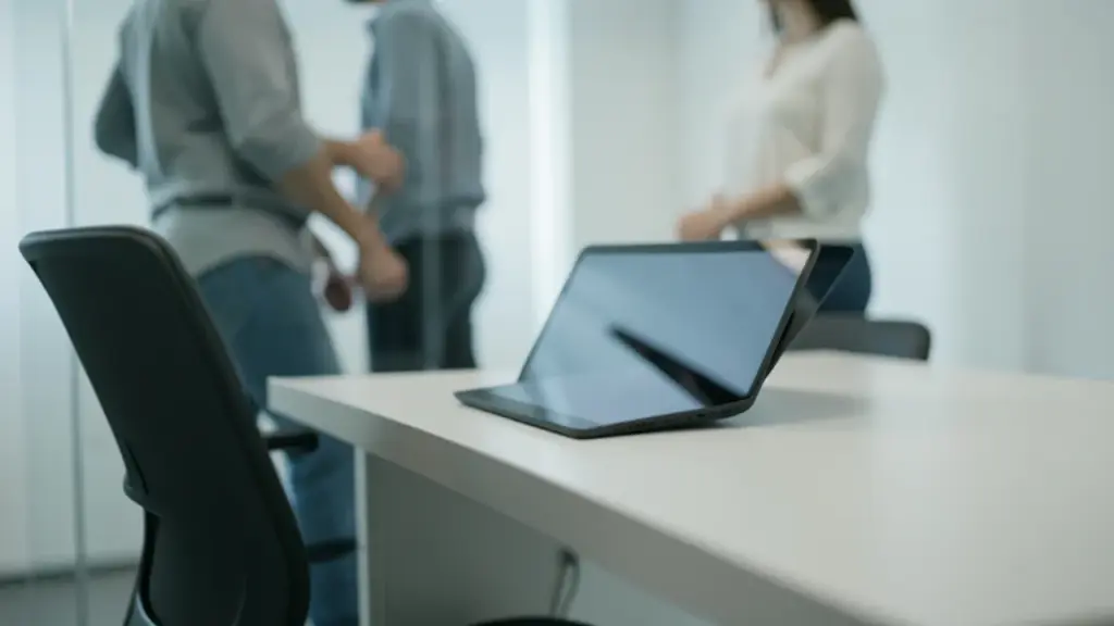 Clinic-like desk with tablet off and empty chair, AI helper vs human touch