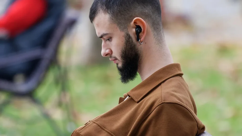Person wearing wireless earbuds while commuting