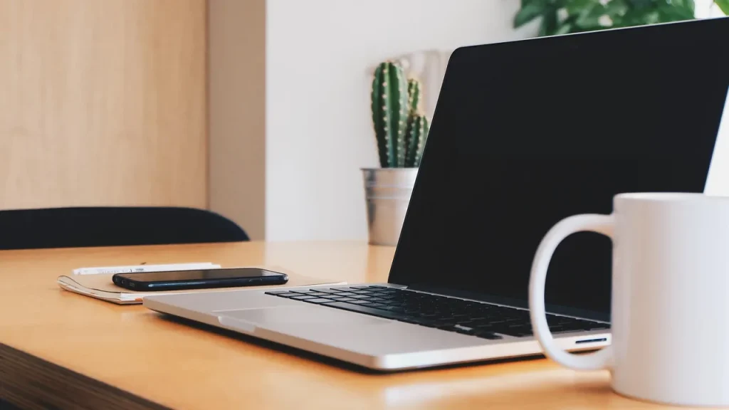 AirPods 5 with a smartphone and charging case on a desk