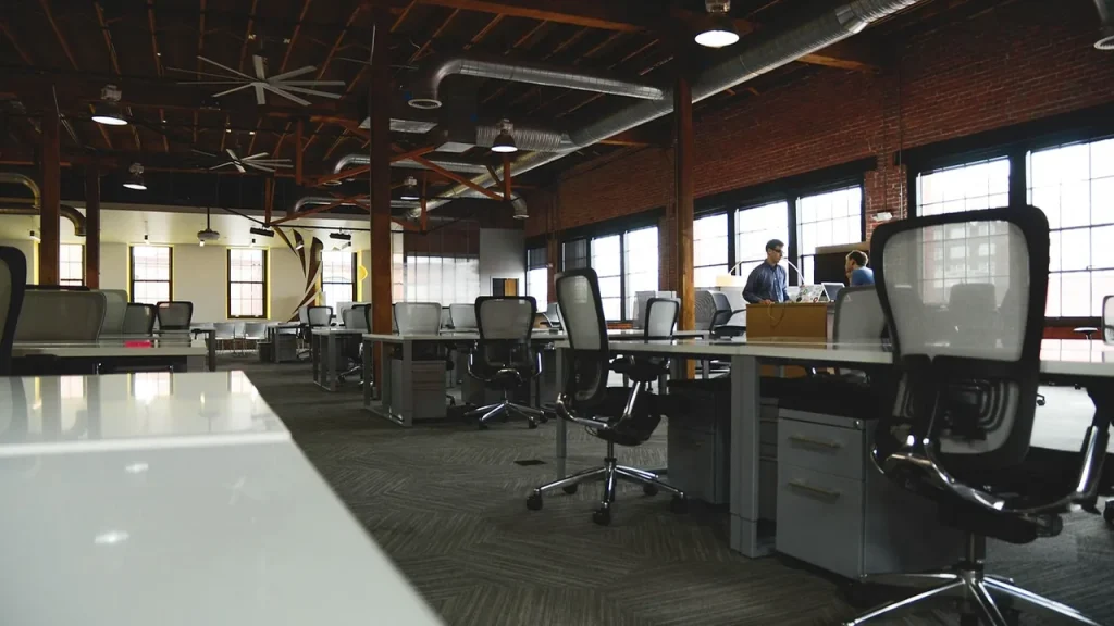 Interior of a modern tech startup office with laptops and whiteboard
