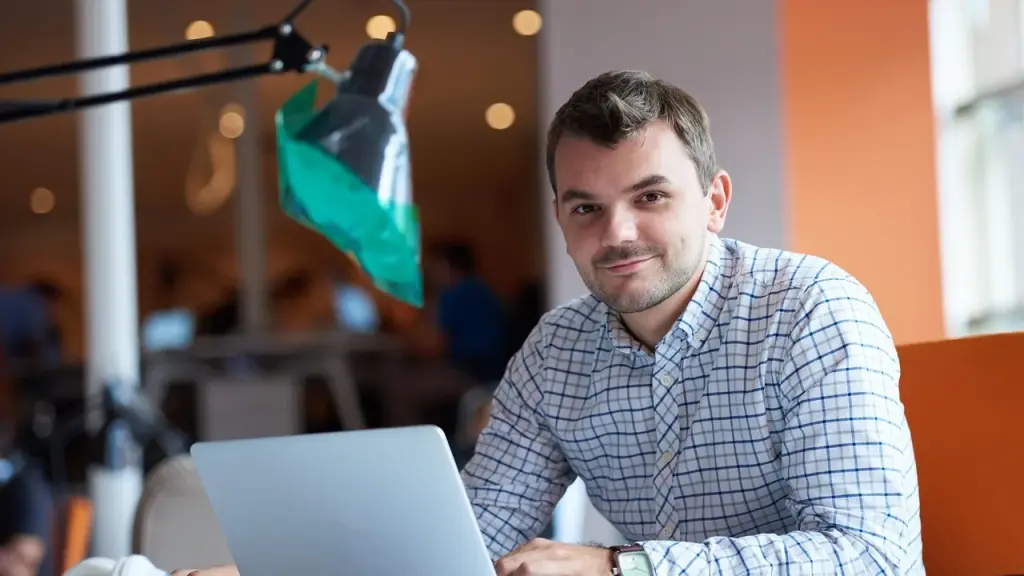 Person typing on a laptop in a modern office