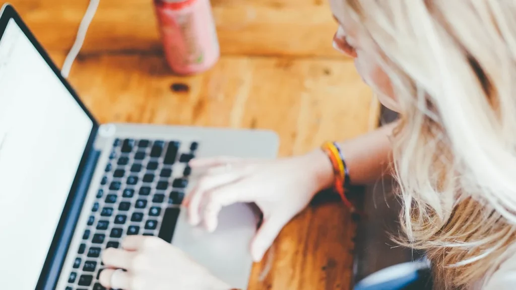 Person typing at a desk with a browser on screen