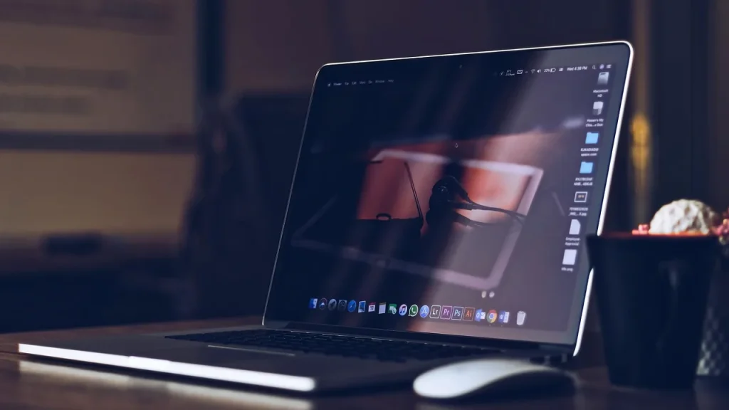 A modern laptop with a vibrant OLED screen in a bright room