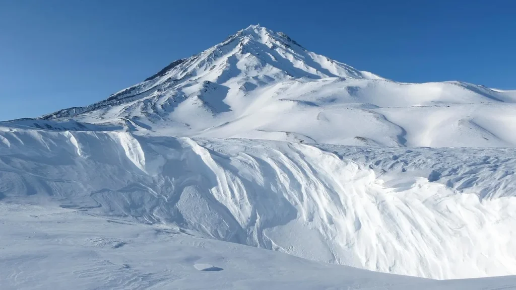 Snow-covered mountain village with a large fallen machine
