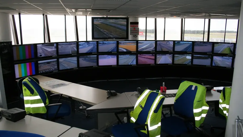 Mission control room with screens showing orbital trajectories
