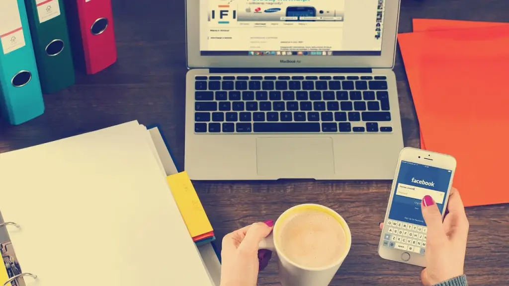 Business laptop open on a desk with notebook and coffee