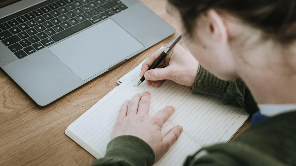 Employees work in a publishing office with computers and papers