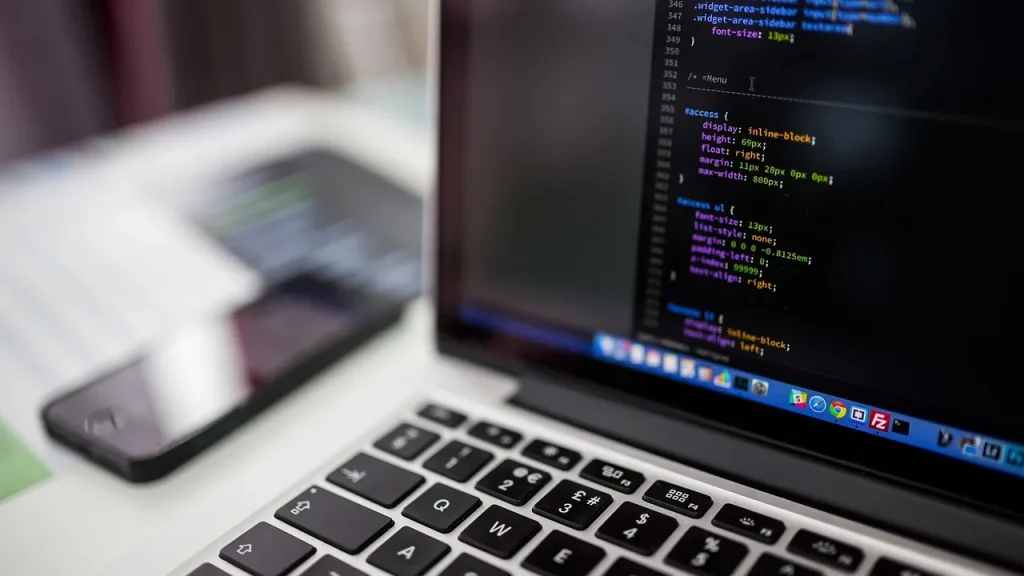 A person working at a laptop with code visible