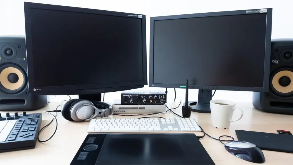 A home office monitor showing a blurred forum page beside headphones