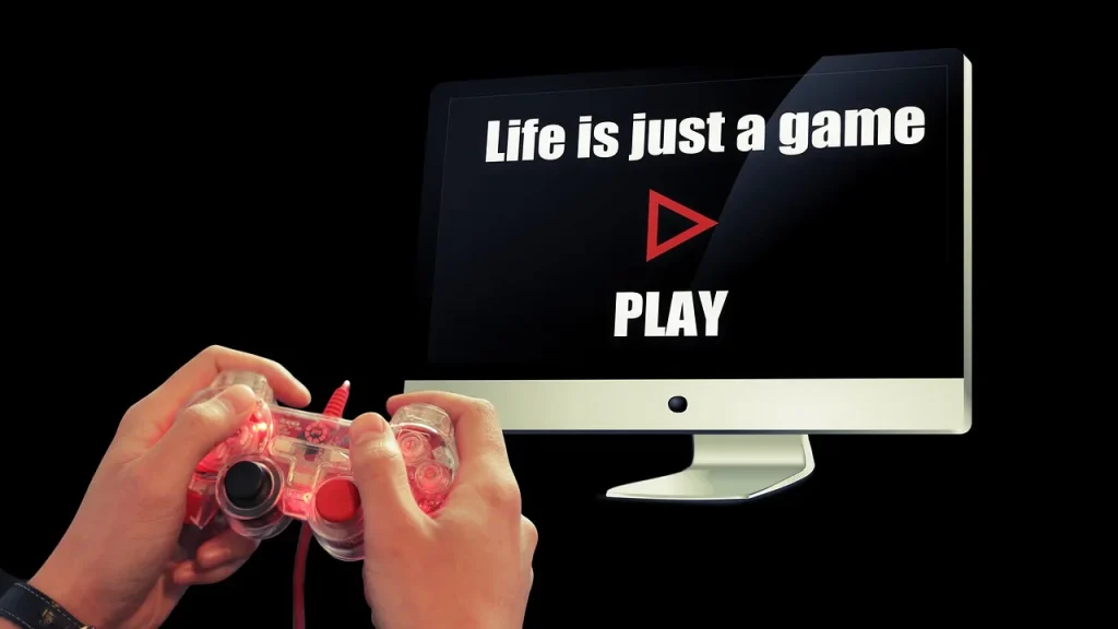 Nahaufnahme von Händen am Controller vor einem Monitor