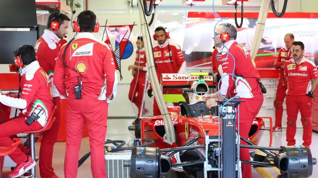Team engineers look at data screens in a garage
