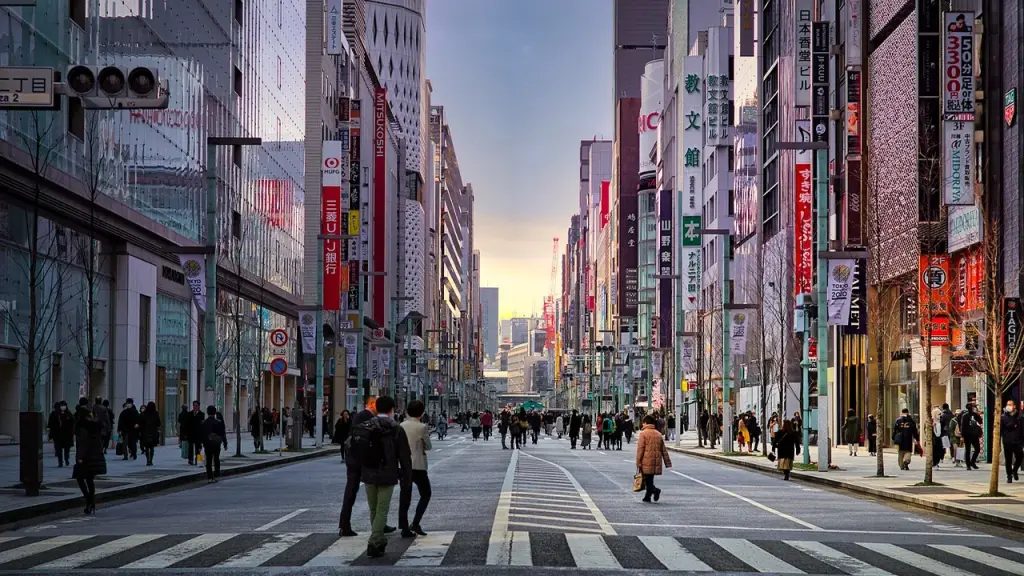 Busy city street at dusk with pedestrians and vehicles