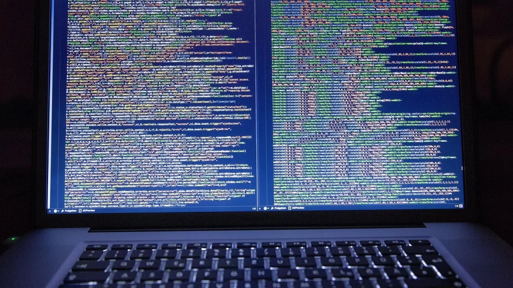 Hands typing code on a laptop with code editor on screen