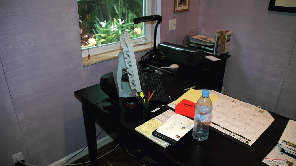 Desk setup with computer, notebooks and a concept sketch