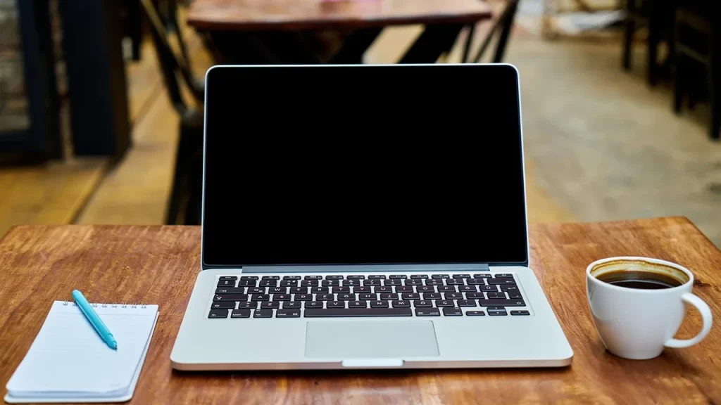 Person using a laptop with the lid LEDs glowing softly