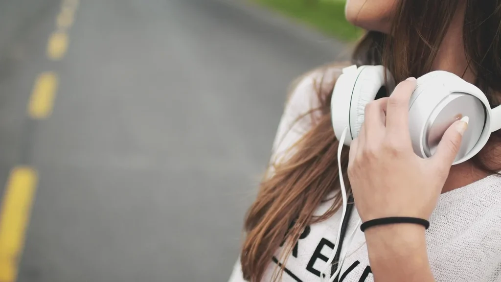 Traveler wearing headphones and using a phone in a car