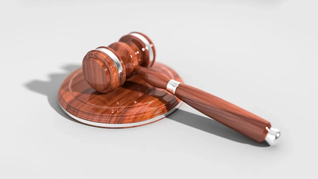 hand holding court documents and a gavel