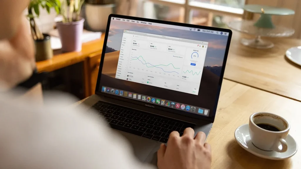 Person reviewing device settings on a laptop in a living room