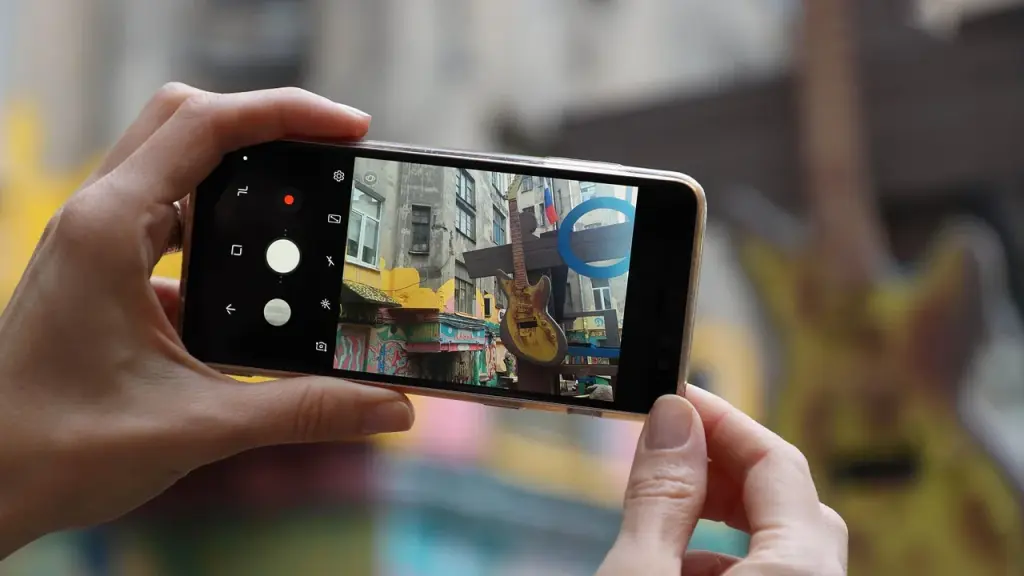 Close-up of a person holding a smartphone with a photo gallery on screen