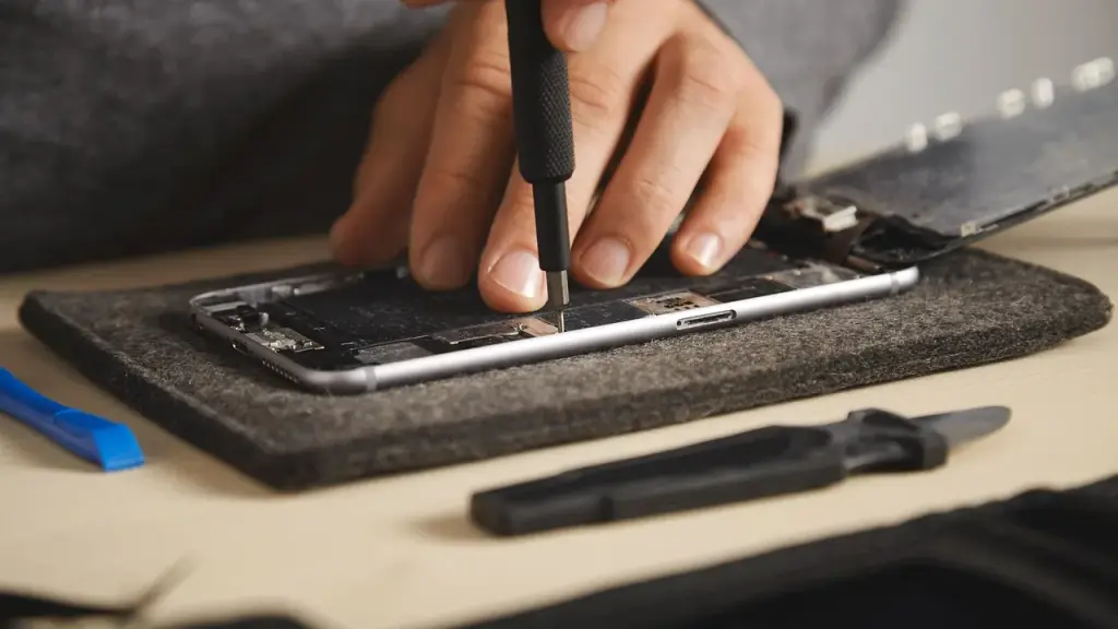 Tech repairing a smartphone with tools