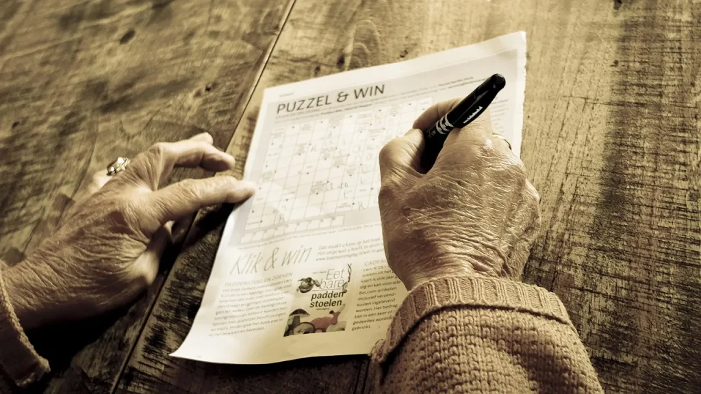 A hand holding a controller over a TV screen showing puzzle grids