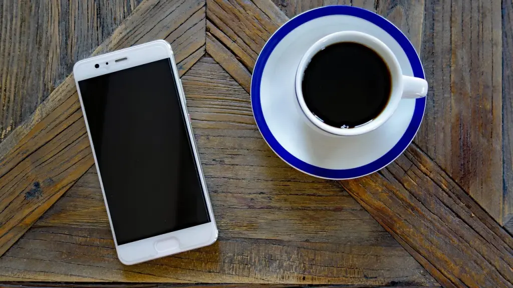 Cup of coffee beside a smartphone showing an app