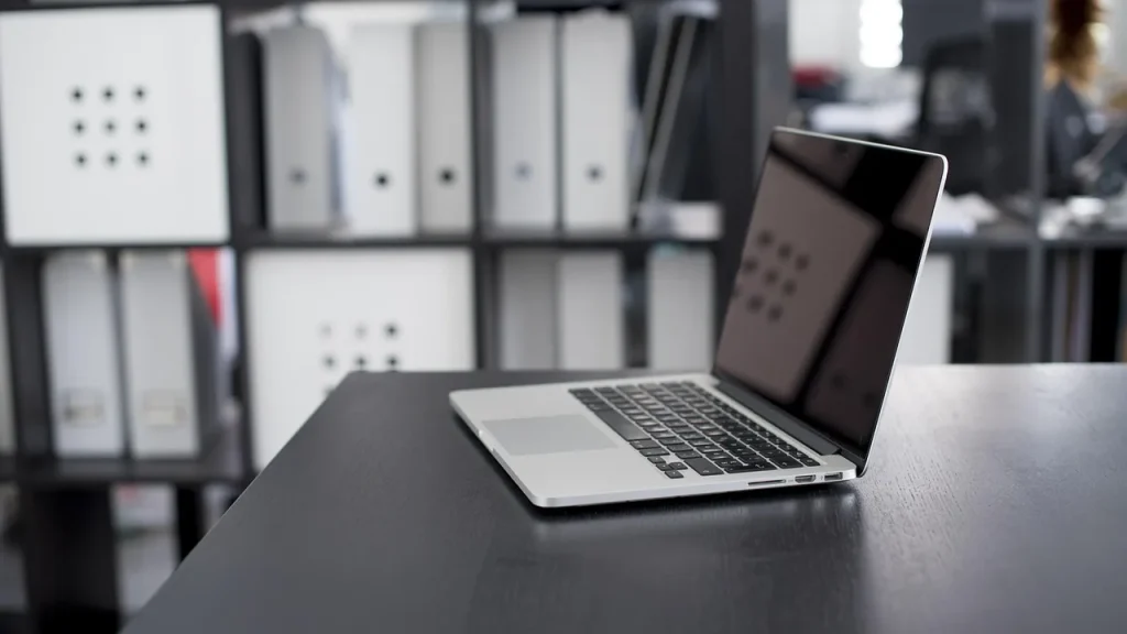 Open MacBook on a desk plugged into a charger