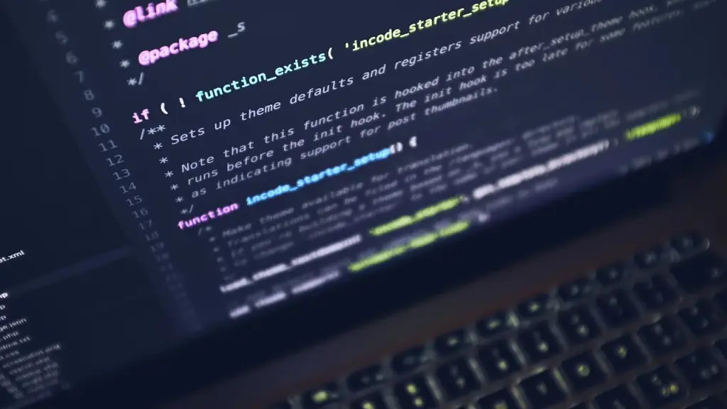 Close-up of a laptop with code on the screen in an office