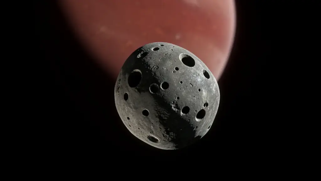 A small cratered moon in front of a red planet