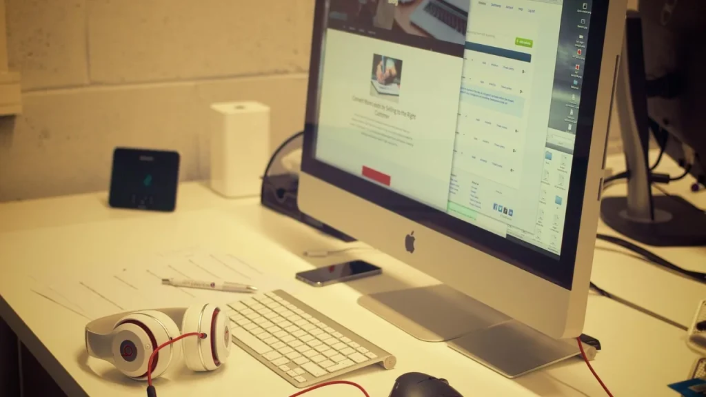 Creative professional setup with a large monitor and laptop