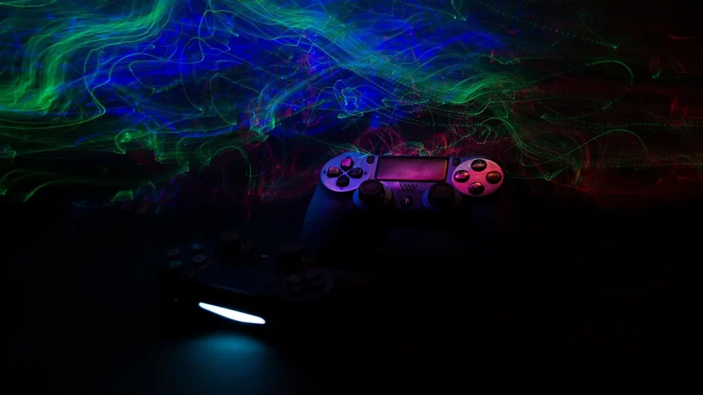 Dark, moody scene with a game console and controller on a table