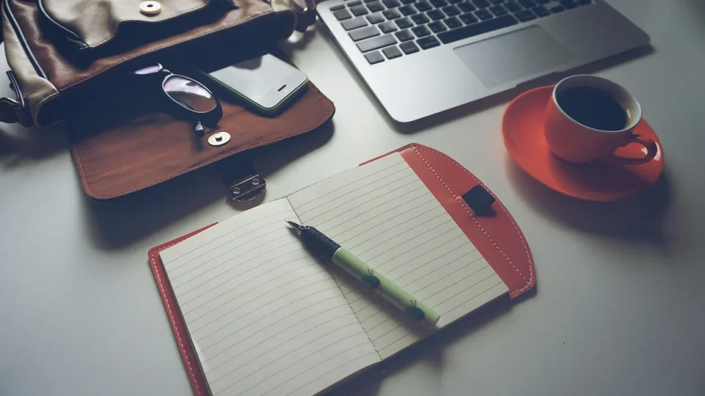 Camera-ready desk with laptop and papers in a newsroom