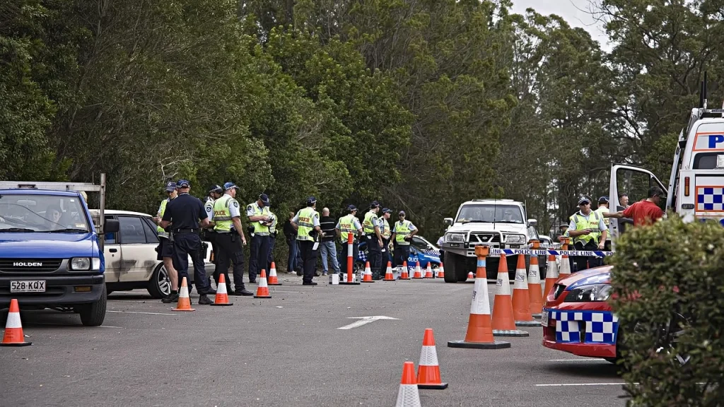 A crime scene with investigators and screens showing data
