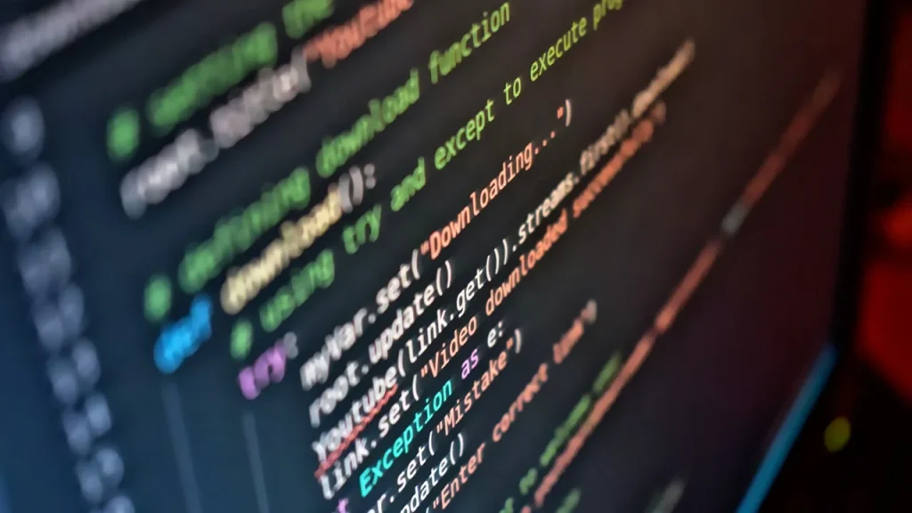 Close-up of a computer screen showing code and AI dashboards