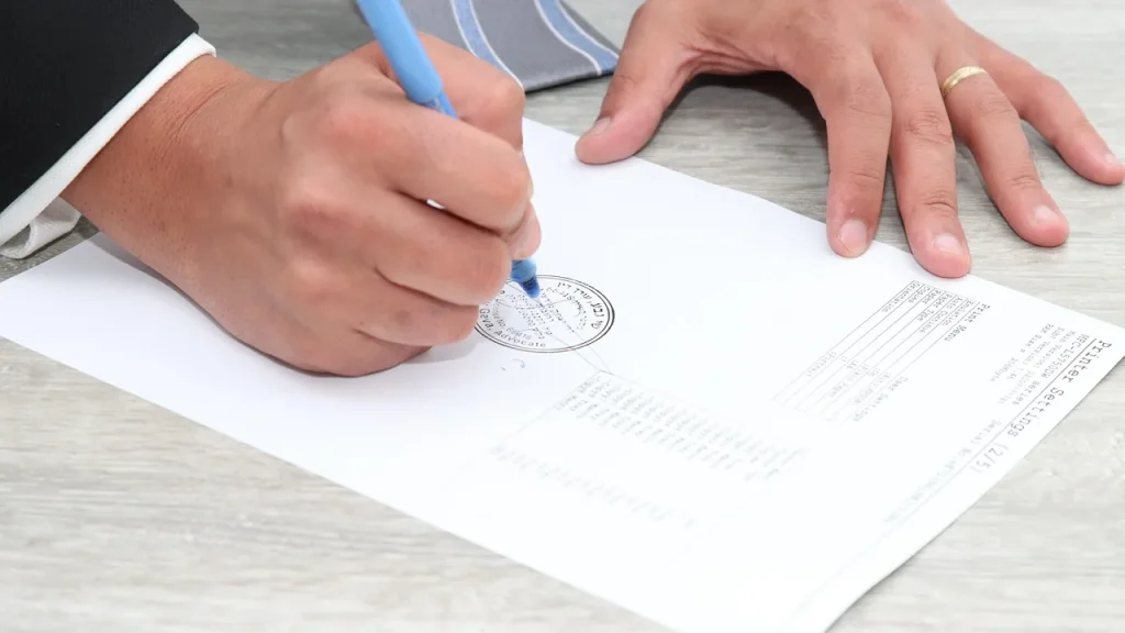 Close-up of a hand signing a document