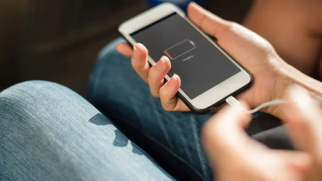 Person holding a phone showing battery indicator