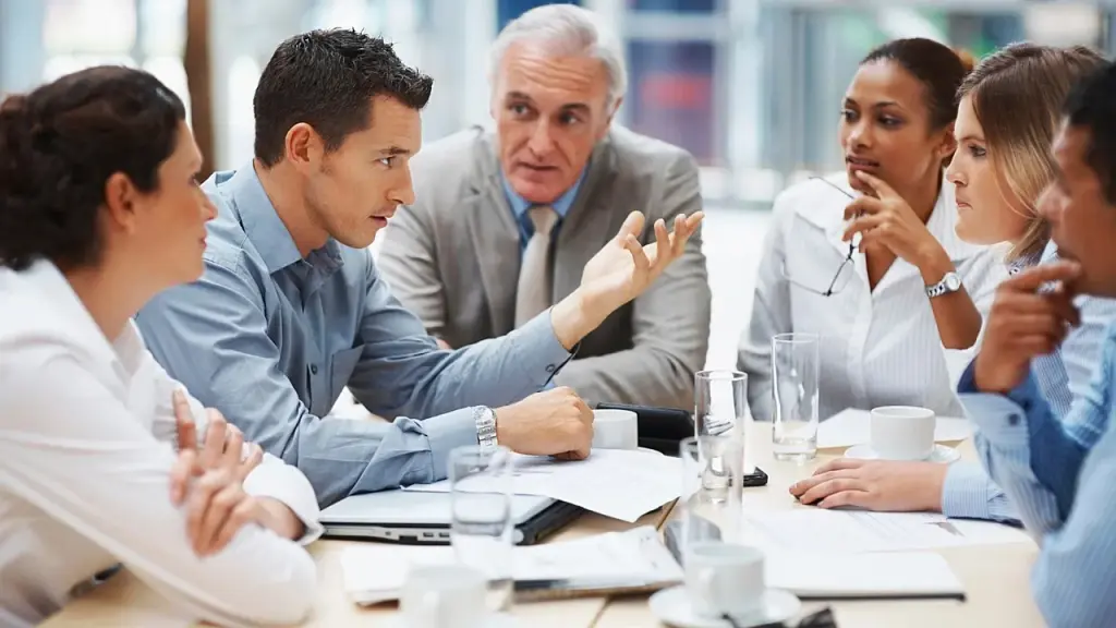Team members discuss lessons learned around a whiteboard