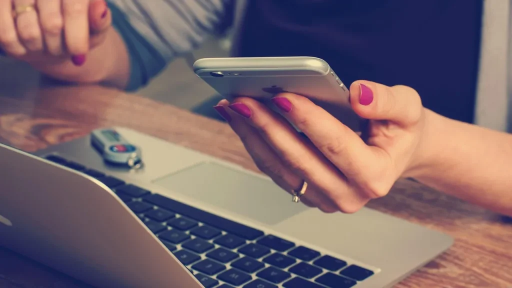Person using a Pixel phone next to a laptop