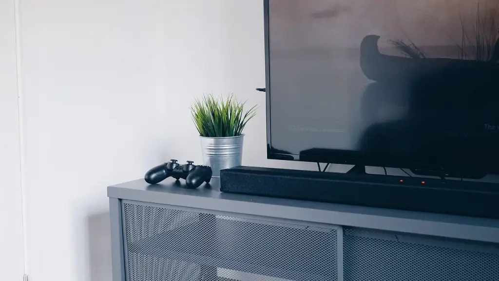 A game trailer playing on a TV with a PS5 controller nearby