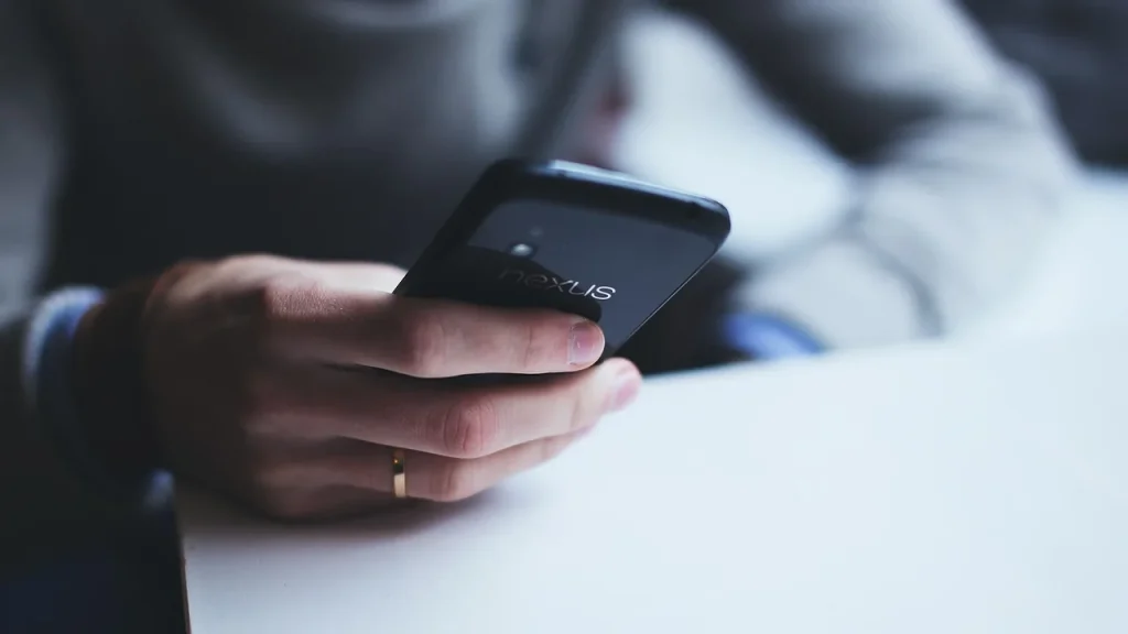 Person holding a smartphone indoors in a bright room