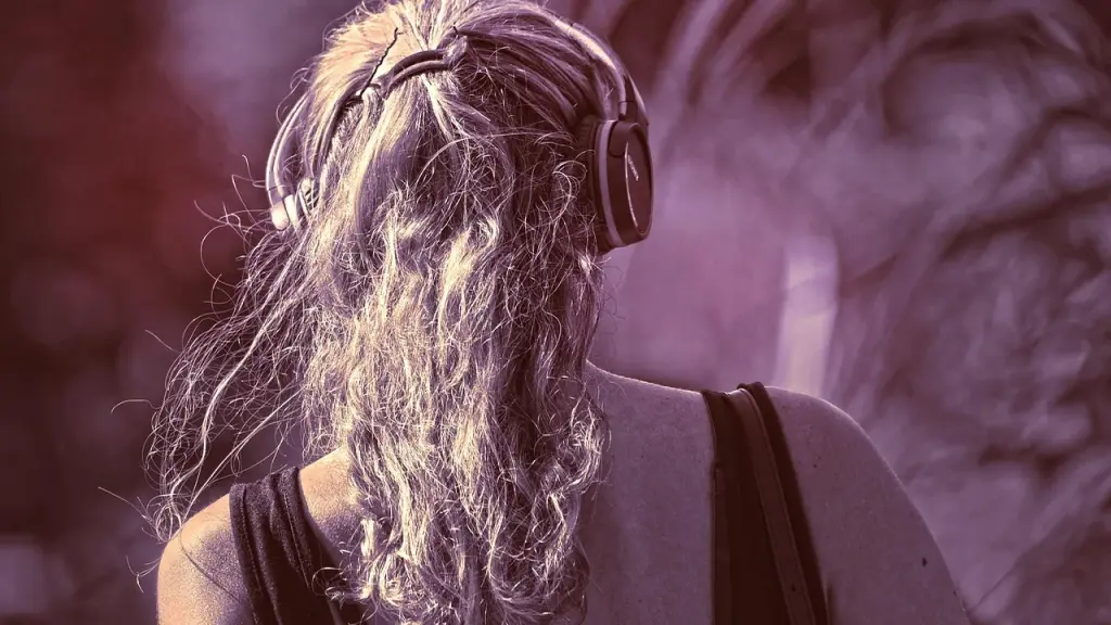 Person wearing open-ear headphones outdoors with city background