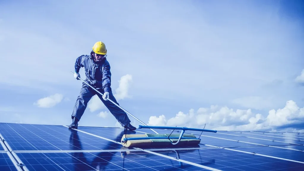 Person cleaning a solar panel with a soft cloth