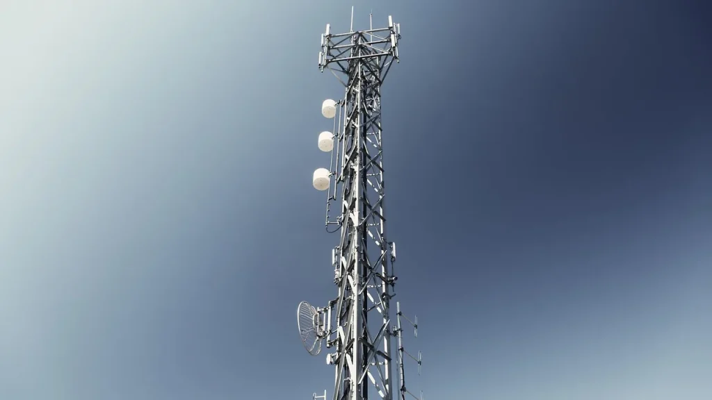 A cellular tower with a satellite dish nearby