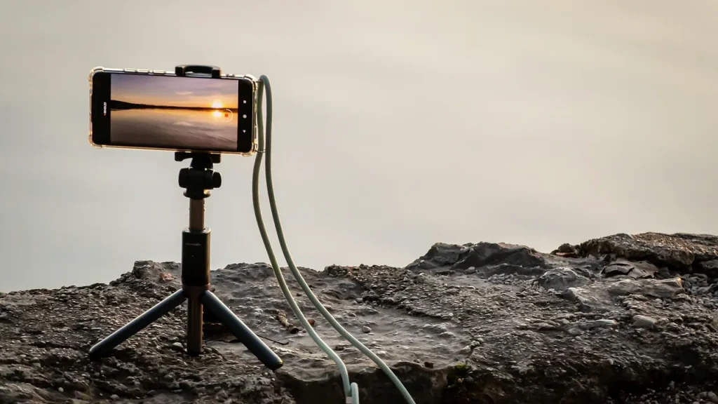 Smartphone mounted on a small tripod on a table