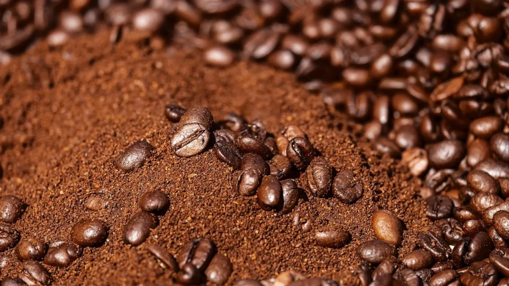 Beans being ground by a high-end coffee grinder inside a machine