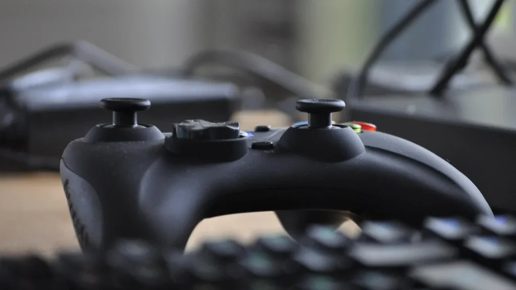 A PlayStation 5 on a shelf with a TV in the background