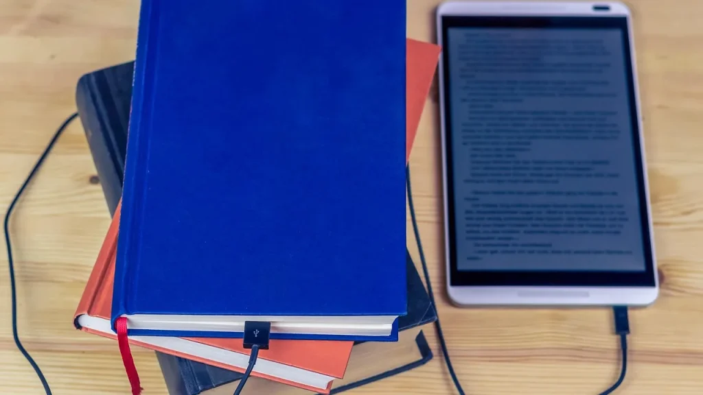 A printed book beside a tablet showing streaming content