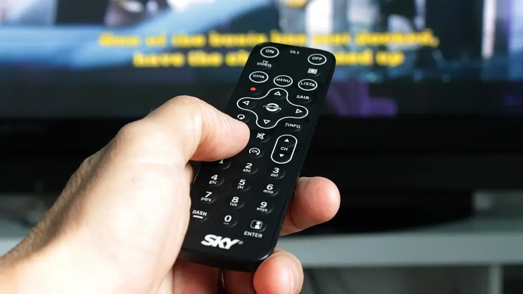 Hand holding a remote with streaming app on screen