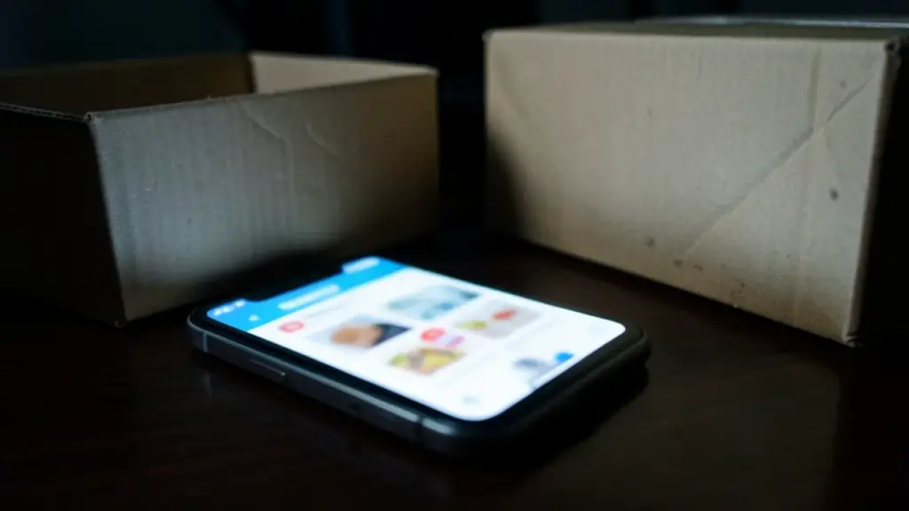 A smartphone with a glowing shopping notification beside a shipping box